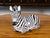 A small vintage Italian hand painted terracotta animal sculpture depicting a zebra lying on the ground, with brown eyes....