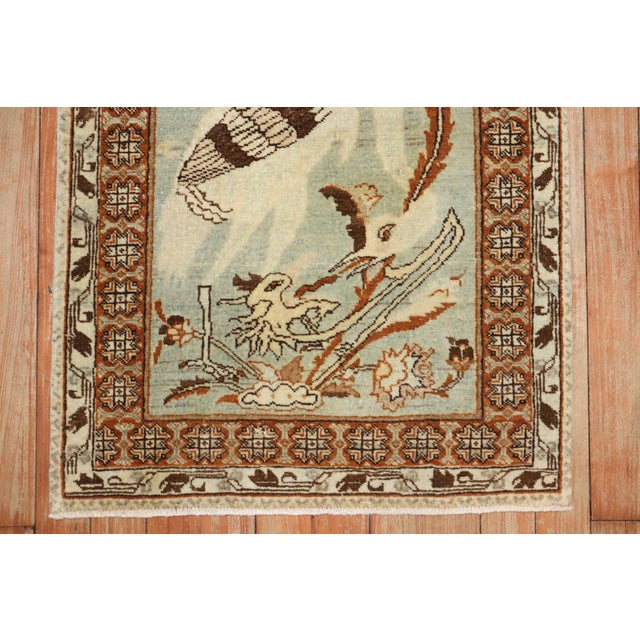 An early 20th century mat size Persian Tabriz rug depicting what looks to be a swan or rooster on a mint green ground. R...