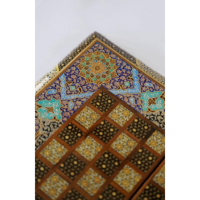 A compact luxury chess and backgammon set combining Khatam marquetry, hand-painted Tazhib ornament, and mother-of-pearl...