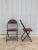 This vintage pair of folding chairs features solid steel frame, original black paint, vintage red vinyl seat & seatback,...