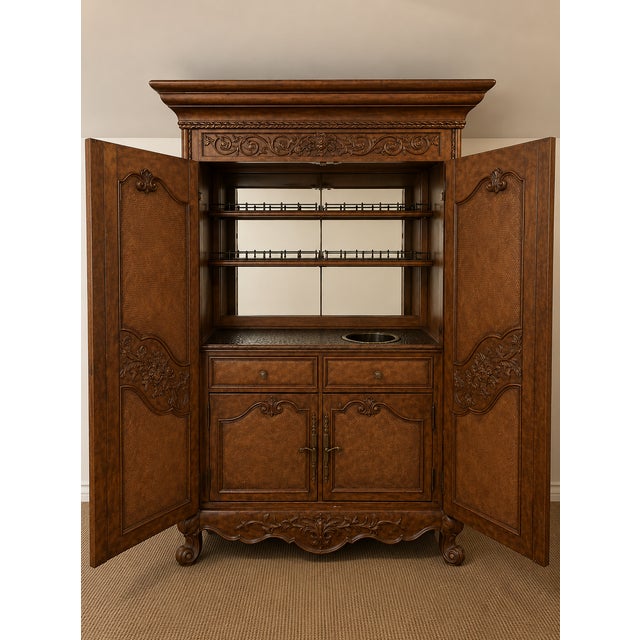 An impressive, oversized home bar armoire combining substantial cabinetry with a fully outfitted entertaining interior....