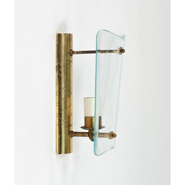 Midcentury amazing pair of sconces in brass and curved glass in the style of Pietro Chiesa for Fontana Arte. Made in Italy...