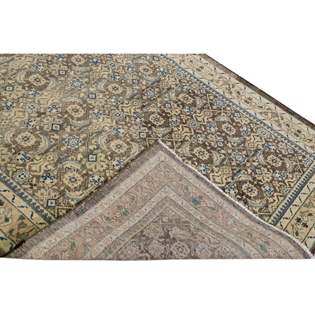 Beautiful vintage Persian distressed hand-knotted wool rug with a brown field. This piece has a beige frame and navy blue...