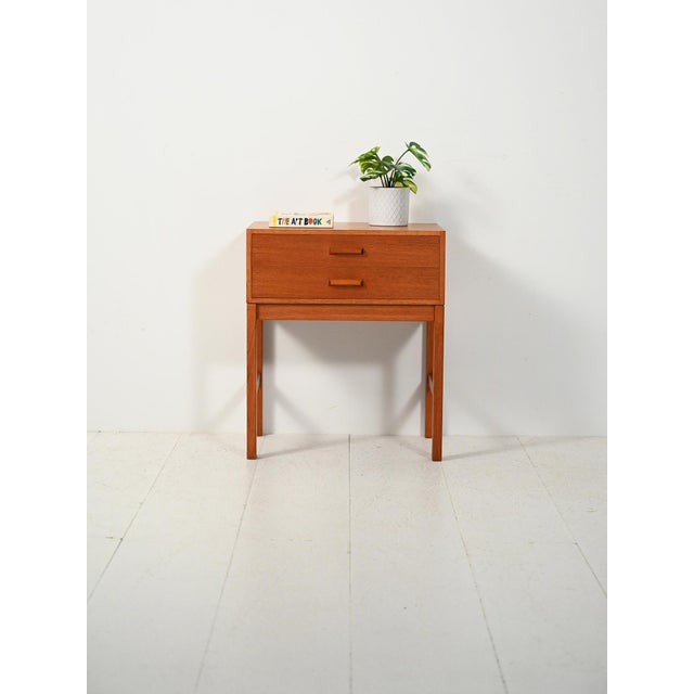 Scandinavian teak bedside table from the 1960s, with two drawers and square handles: clean lines, light proportions, and a...