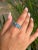 This stunning 925 Sterling Silver ring showcases the brilliance of three oval-cut Blue Topaz gemstones, beautifully...