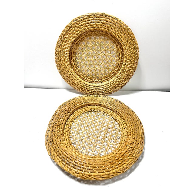 A beautifully crafted set of four vintage woven rattan and cane plate chargers featuring a tightly braided outer rim and...