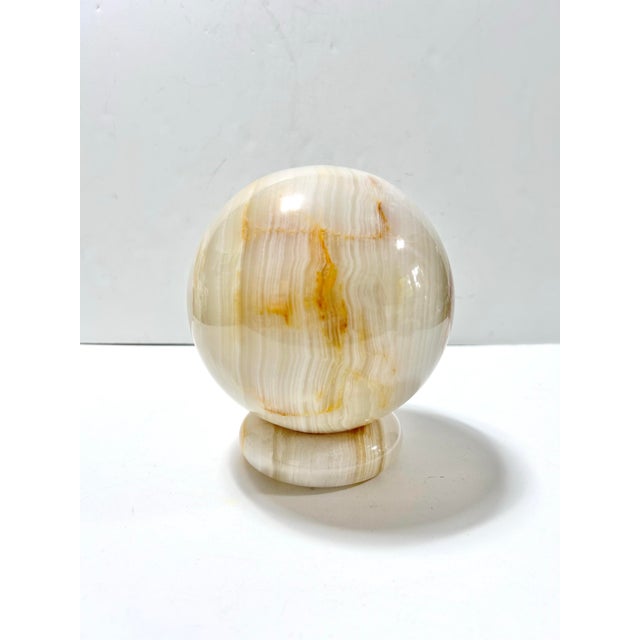 An exceptionally substantial vintage banded onyx sphere weighing nearly 12 pounds, with dramatic natural layers of ivory,...