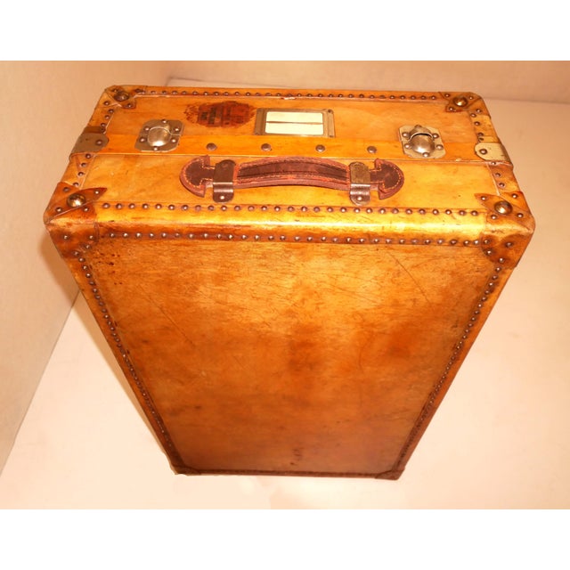 Leather travel trunk with wooden structure and metal studs. There are 2 working locks with keys, leather handles and...