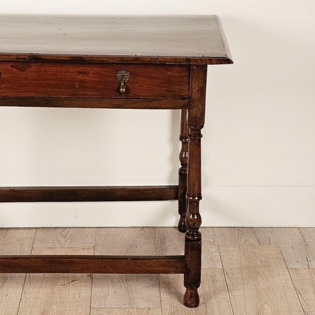 A one-drawer walnut tavern table, English or American, circa 1720.