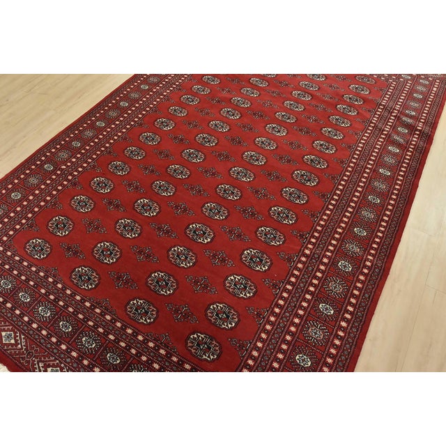 A tribal Bokhara rug hand-knotted with fine wool on a cotton foundation. This rug features rows of repeating medallions...