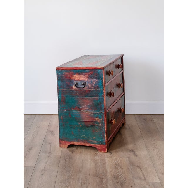 A darling 19th-century painted chest of drawers, featuring its original timeworn polychrome surface in deep red, teal, and...