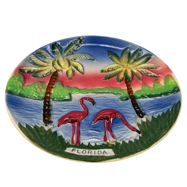 Mid-century pink and green ceramic flamingo theme decorative wall plate. The wall plate features a beautifully detailed...