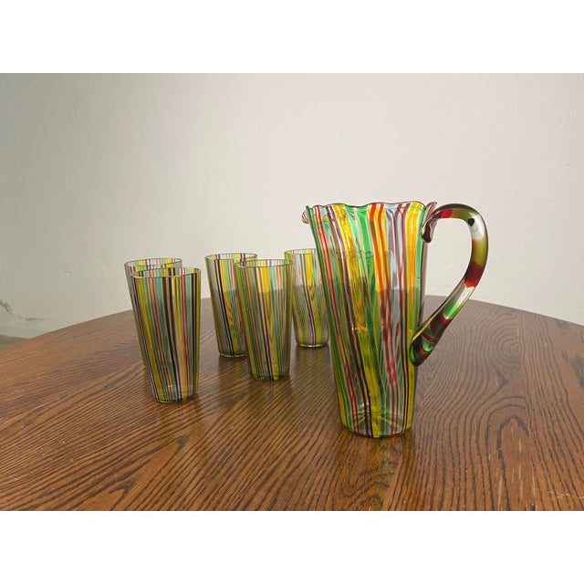 Set of 6 glasses and a carafe in six-color reed glass, designed by Gio Ponti for Venini in the 1950s. The set has been...
