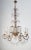 An Italian crystal chandelier in Empire style made with a gilded structure adorned with swags of crystals that glitter...