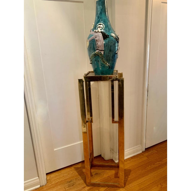 48 inch tall brass metal stand in the deco style - smoked glass top. A compliment for sculptures, vases, etc.