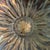 Sunflower shaped, 14” in diameter, 3” deep; iridescent gold, bronze, and, browns; circa early 2000s; unknown artist/maker.
