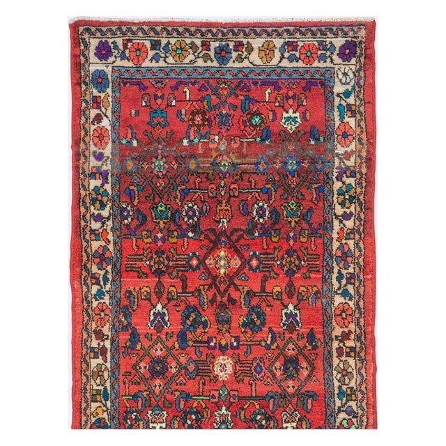 A vintage Persian Hamadan rug in runner format handmade during the mid-20th century with the traditional Persian 'Herati'...