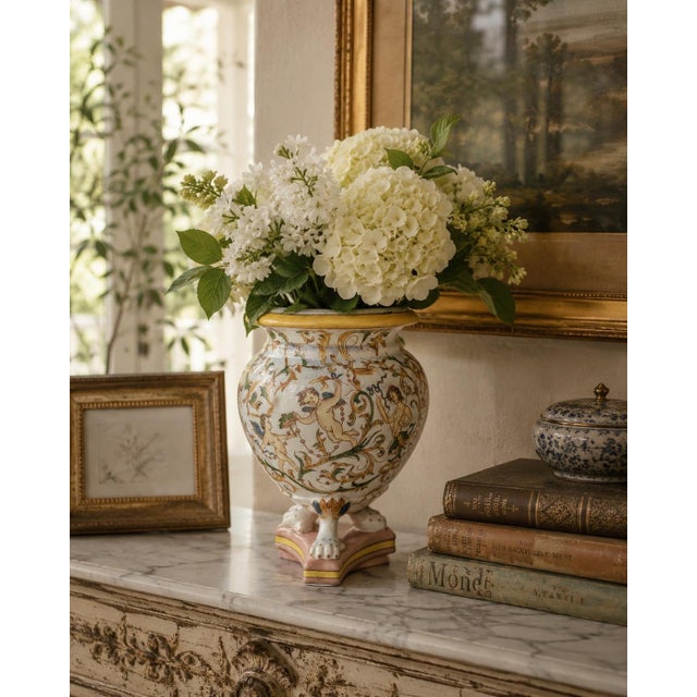 A richly decorated neoclassical faience vase painted with classical putti, scrolling acanthus foliage, garlands, and...