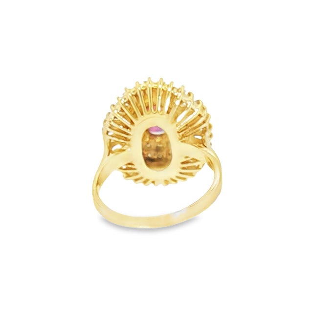 A late 20th-century statement cocktail ring featuring an approximately 1.0-carat oval red ruby. Surrounded by...