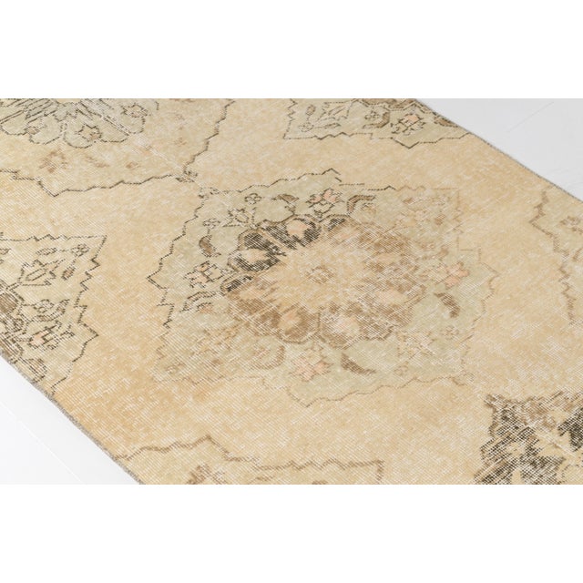 This is a vintage Turkish Oushak rug from the Mid 20th Century. The piece was hand-knotted.