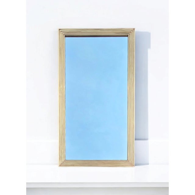 This 19th Century French Reeded Brass Frame Mirror has elegant neoclassical symmetry while also strikingly modern. Mirror...