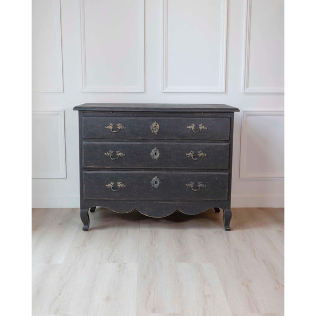 A Swedish writing desk commode dating to circa 1760, crafted in pine and finished in a richly aged dark paint with...