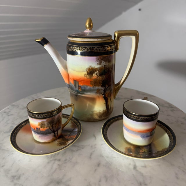 A vintage three-piece porcelain chocolate or demitasse coffee service hand-painted by Noritake in Japan. The set includes...