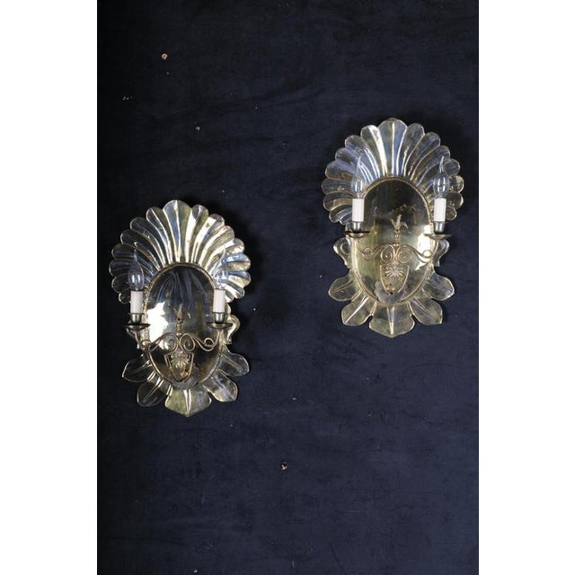 Pair of antique brass shell-shaped wall sconces/blakers, 20th century Shell-shaped mirrored back panels with two sconce...