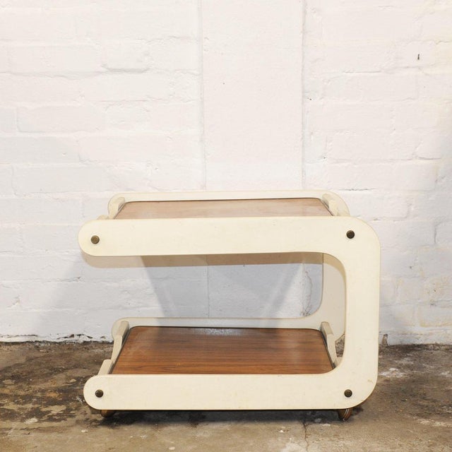 A stylish vintage painted wooden two tier drinks trolley dating from the 1970s, featuring a distinctive cream-coloured...