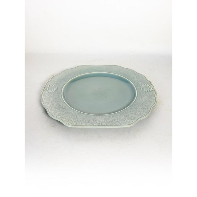 A French ceramic dish from the 1970s, with an elegant, slightly scalloped shape and a soft, luminous celadon blue hue. The...