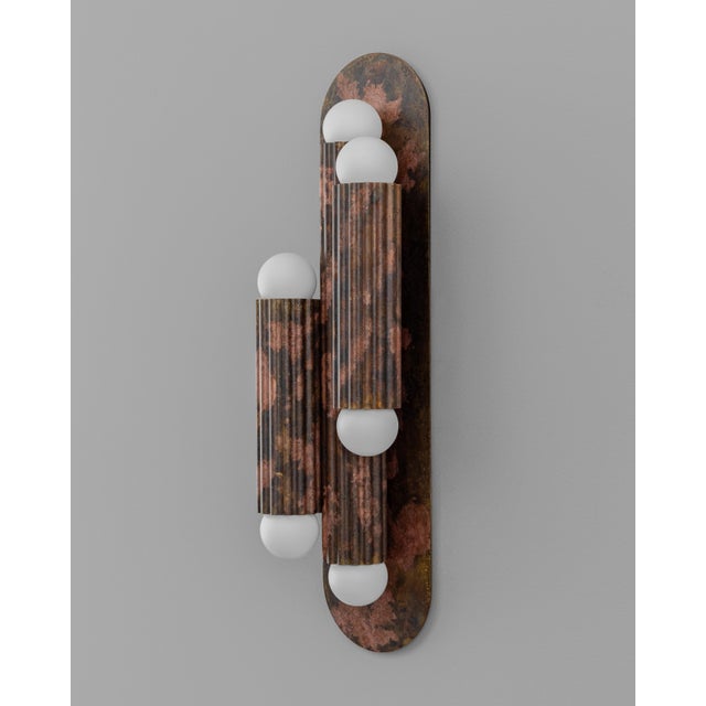 A single fluted cylinder rests on an oval plate, its geometry distilled to pure form. Entirely crafted in solid brass, it...