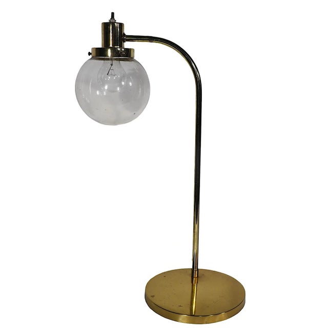 Chic postmodern desk lamp having a brass base, and arc form arm, with a tinted glass ball globe shade. The lamp is in...