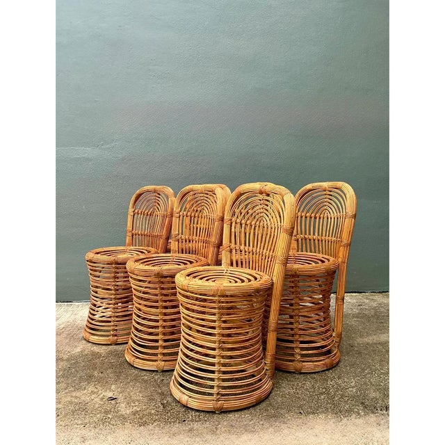 This set of six vintage rattan dining chairs showcases an elegant arched backrest design, with vertical rattan strands...