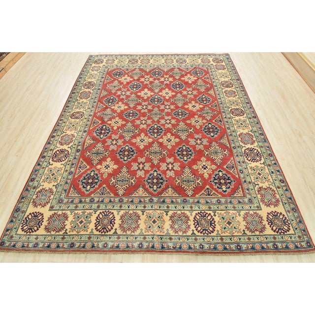 This traditional tribal geometric Caucasian Kazak rug is hand-knotted with an all-wool pile on a cotton foundation. This...
