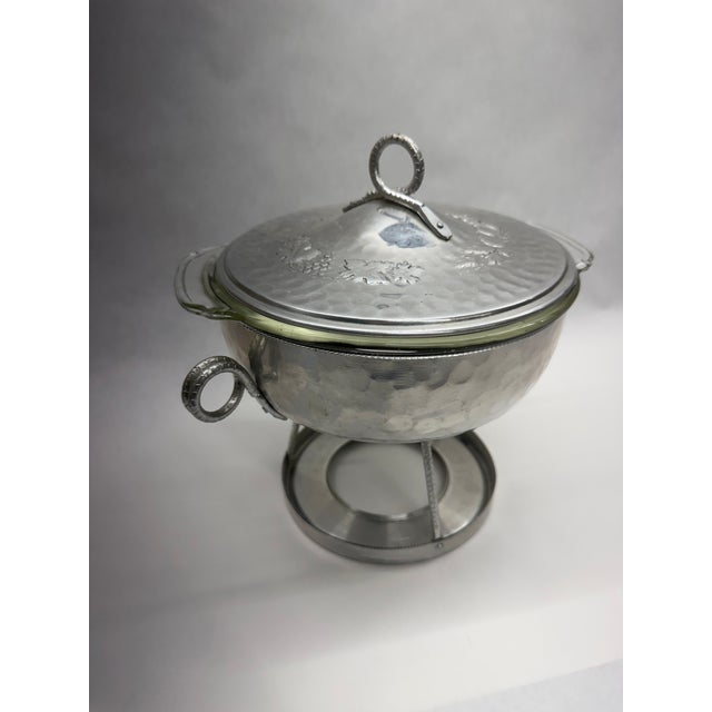 Charming vintage mid-century hammered aluminum covered casserole serving dish complete with its original warming stand and...