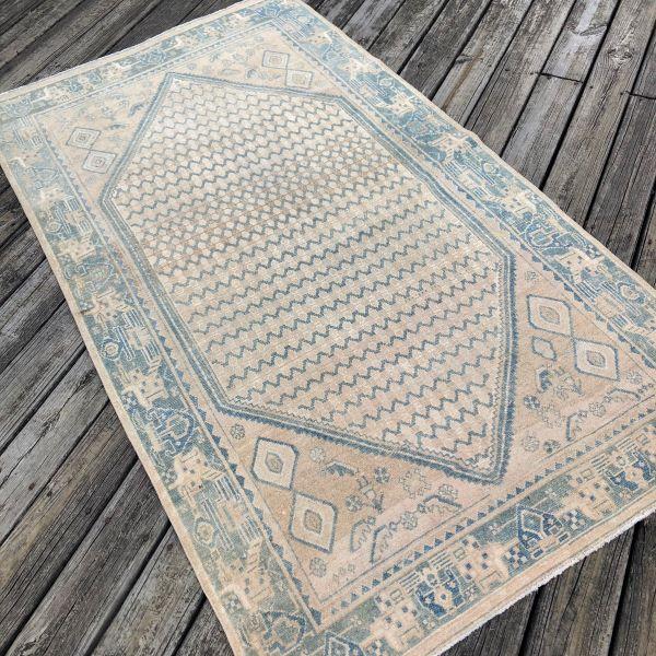 A timeless antique Persian rug distinguished by its soft, faded palette and beautifully balanced geometric design. Hand-...