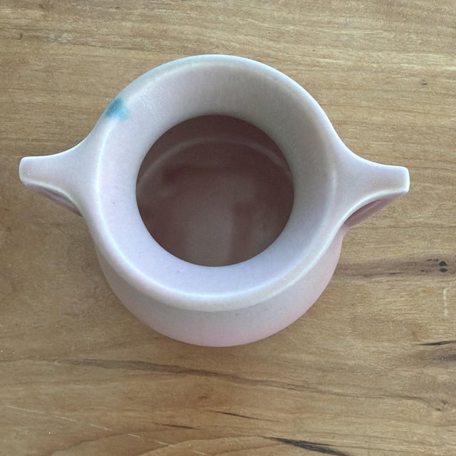 Authentic Rookwood Pottery vase dated 1928, featuring a soft matte pink glaze with subtle green and blue flecking. Classic...