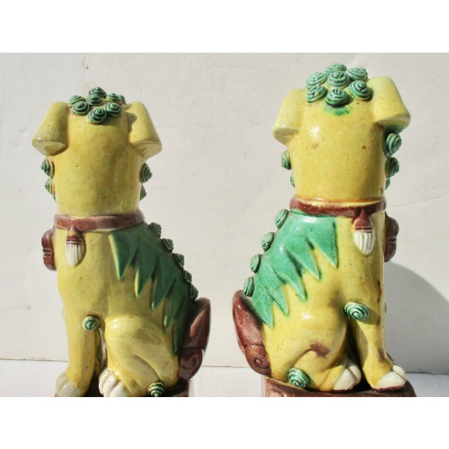 The classic pair of mother and father foo dogs on a high diapered throne. Tri-color: yellow, green, and brown. Each is "as...