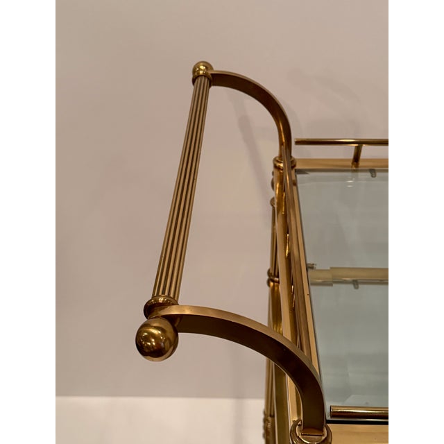 Elegant Regency style brass and glass, two handled and 3 tiered Italian mid century bar cart on casters. Space from middle...