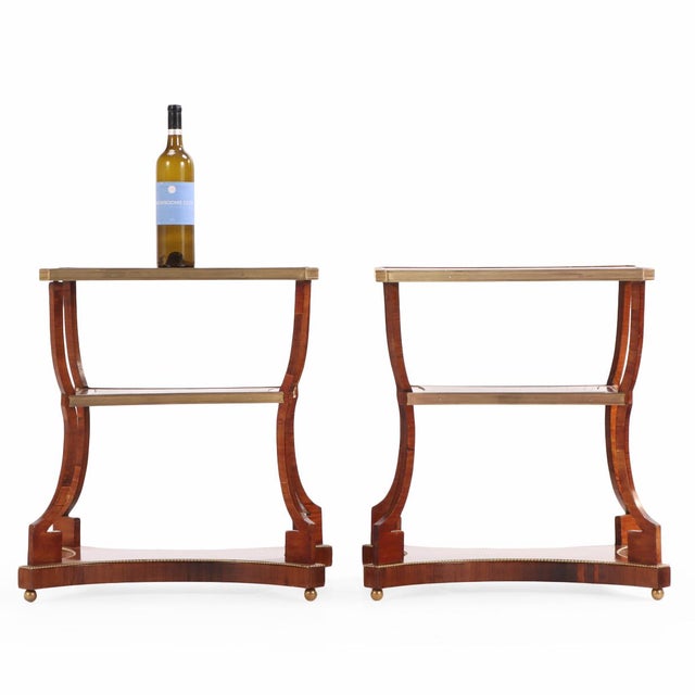 A fine and sophisticated pair of Regency-style three-tier end tables, crafted in Argentina circa 1900, showcasing...