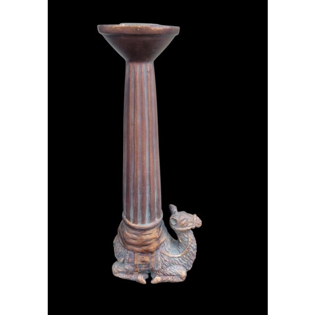 A wonderful pair of camel carved tall candle holders. The holders are mad eof some sort of man made sculpture or resin...