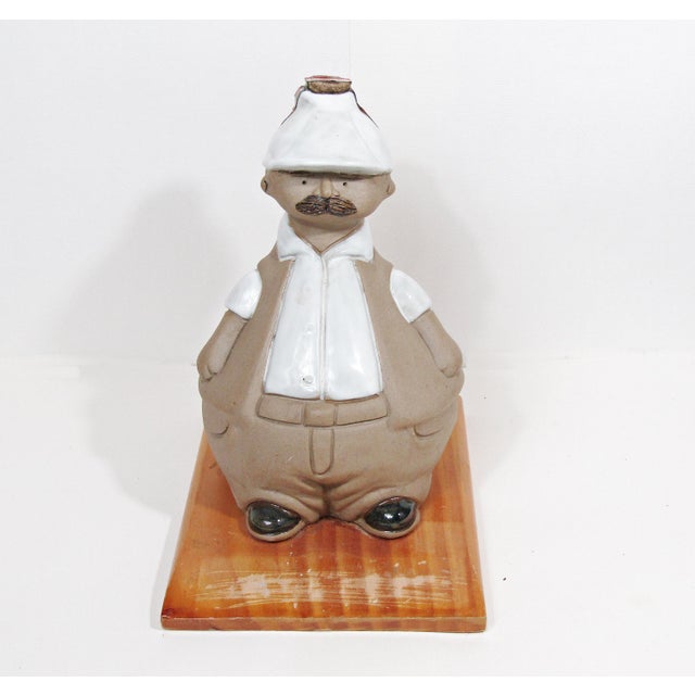 A playful, mid-century-spirited bar accent: a large ceramic decanter modeled as a stout gentleman with a crisp white shirt...