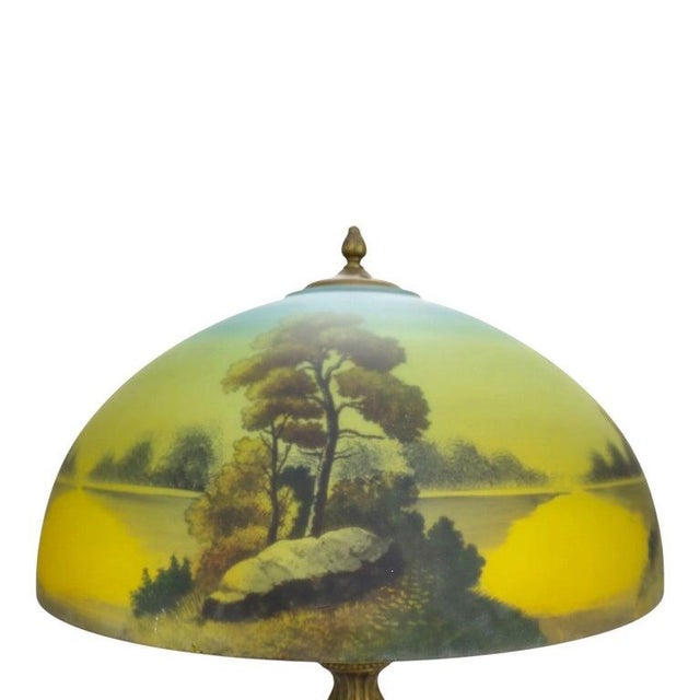 Arts & Crafts table lamp attributed to Phoenix, circa 1920, with a domed reverse-painted glass shade and an ornate,...