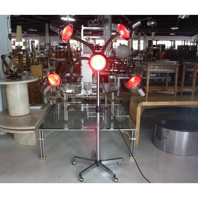 Very unusual Mid-Century Modern chrome base four flexible arms lamp. Currently showed with five red heat bulbs.