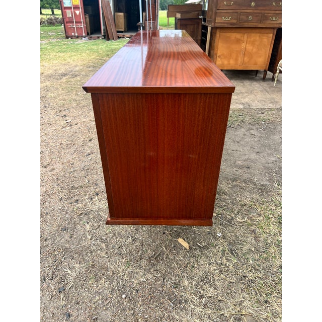 An elegant French Mid-Century Modern sideboard from the 1960s, showcasing clean architectural lines, tapered legs with...