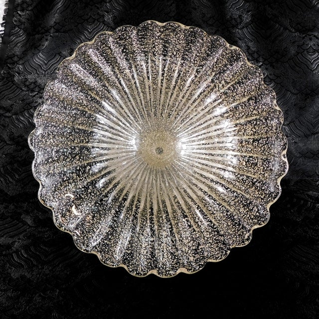 This is a large footed clear glass bowl with gold glitter in it. I do not know who made it, but I believe it is vintage...
