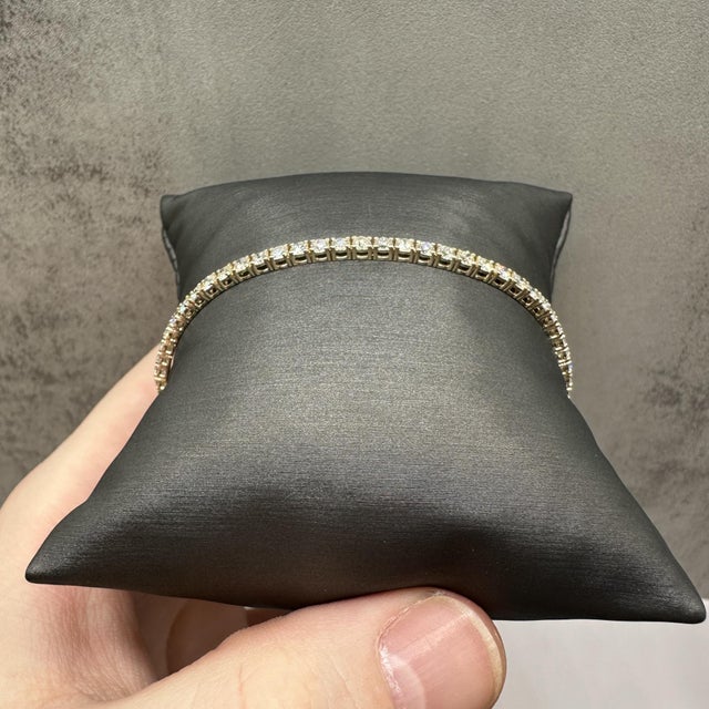 This stunning natural diamond tennis bracelet in 14kt yellow gold features 3.5 carats total weight of GH SI2–I1 round...