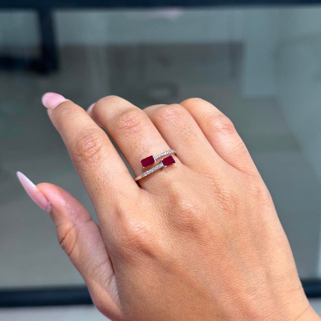 This open bypass ring showcases 0.97 carats of natural emerald-cut rubies, set in 14k white gold. Each ruby measuring...