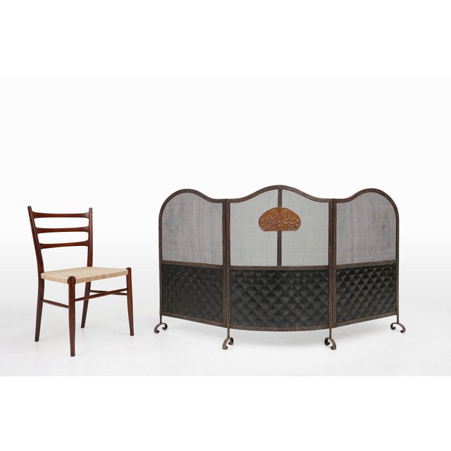 A large Art Deco wrought iron fireplace screen with 3 panels. Crafted in France around 1915. This exquisite piece serves...