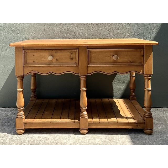 This handsome center island is a masterclass in rustic farmhouse design, crafted from substantial knotty pine with a warm,...